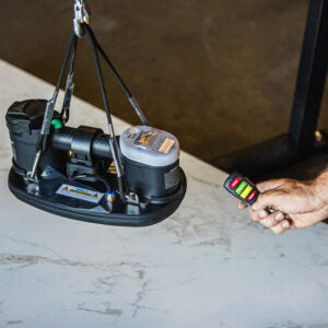 GRABO GR-V1 remote demonstrated with a suspended GRABO lifter. Application photo; lifting rig and lifter are not included.
